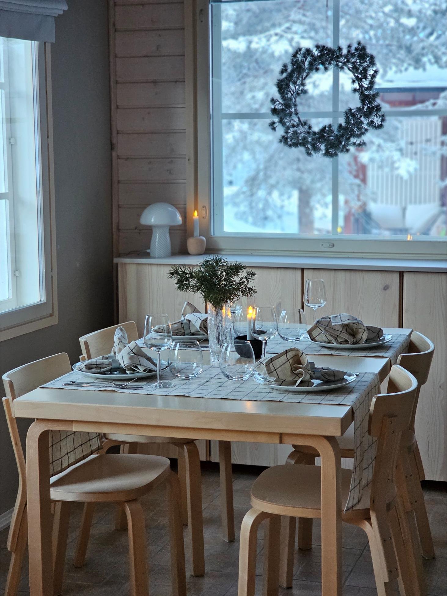 Katettu ruokapöytä mökin ruokailutilassa.