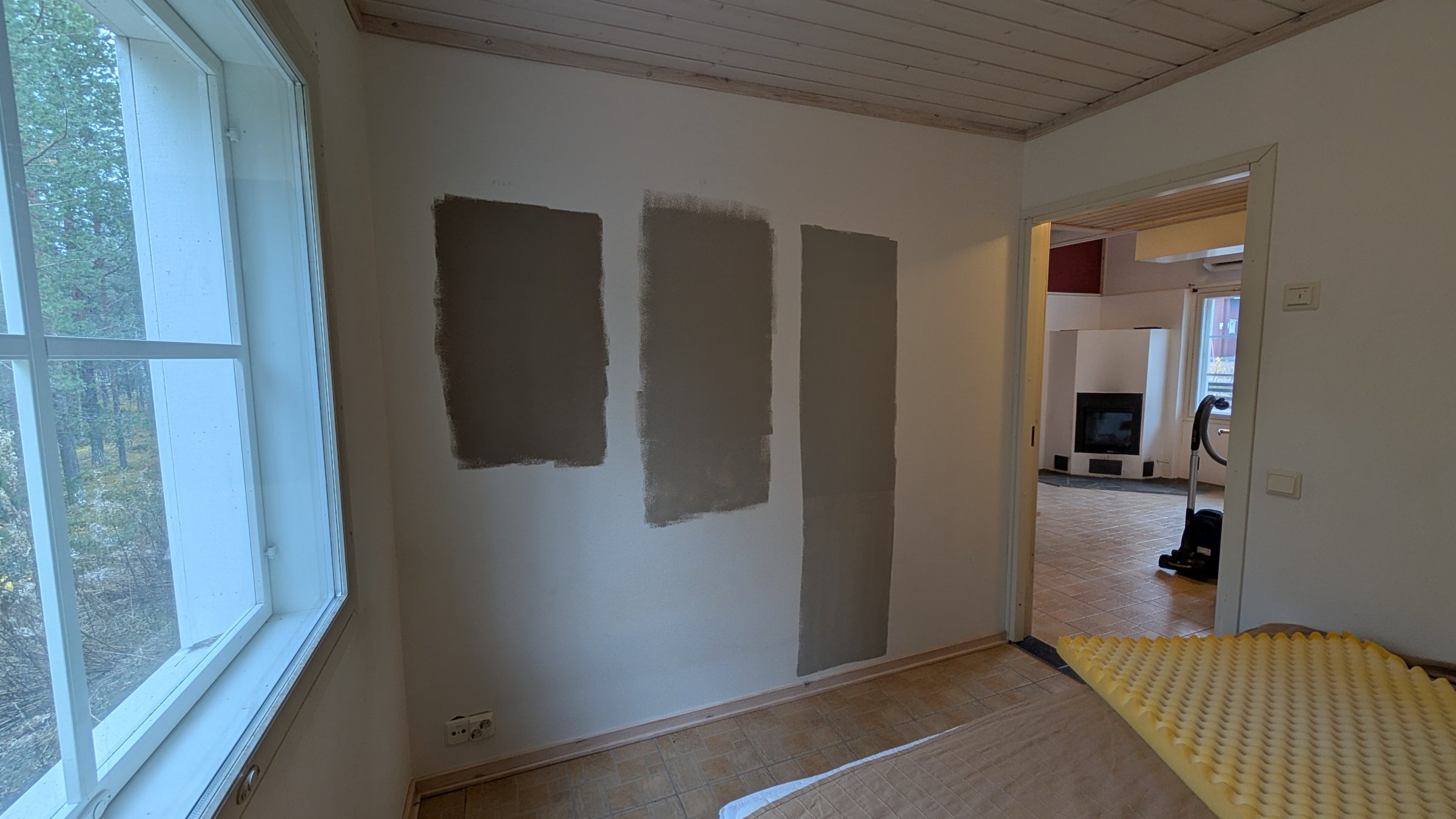 Tummempien sävyjen testimaalauksia makuuhuoneen seinällä.